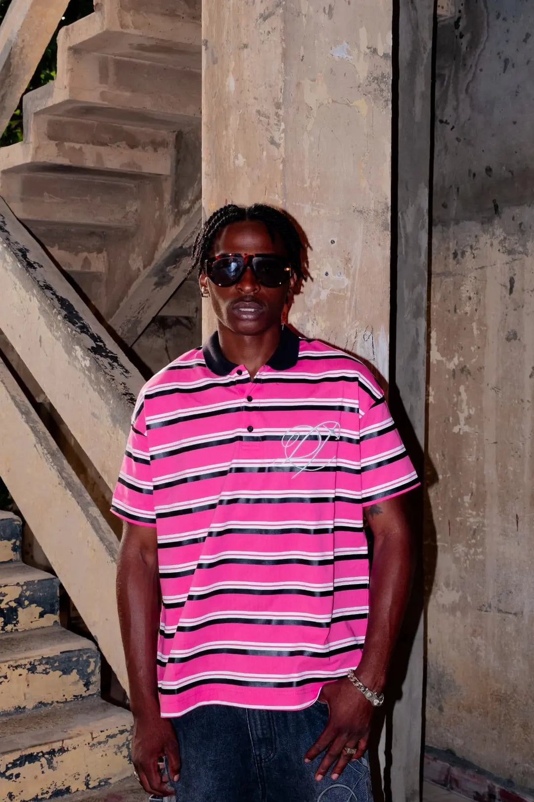 Model in the pink striped DROP polo against concrete stairs