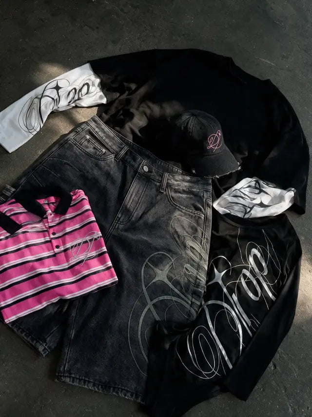 Heritage pieces laid out on concrete: striped polo, denim shorts, tee and cap