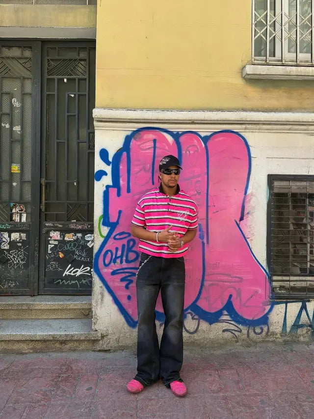 Model in the striped Heritage polo in front of a graffiti-covered wall