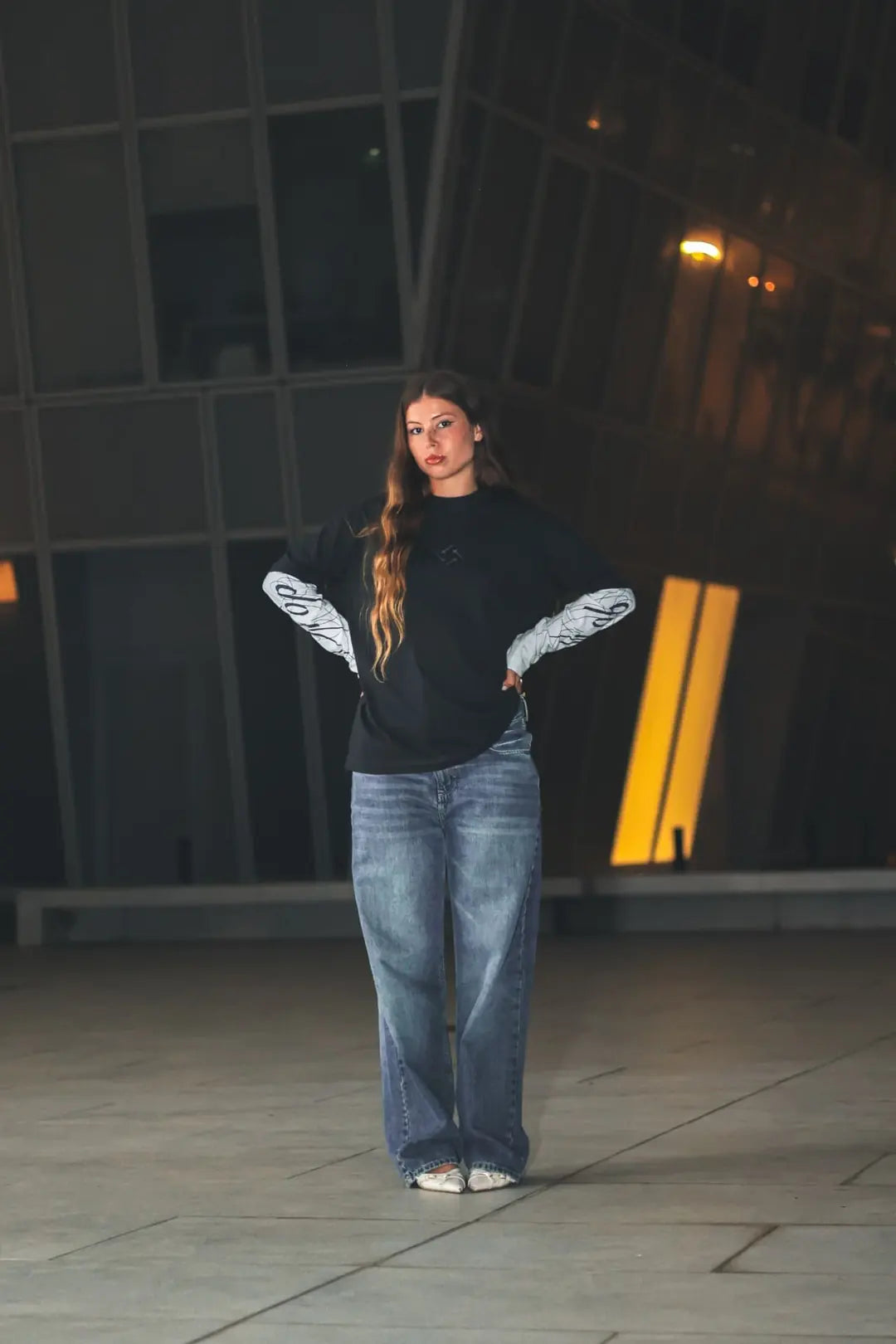Model wearing the DROP long sleeve and denim on a rooftop at night